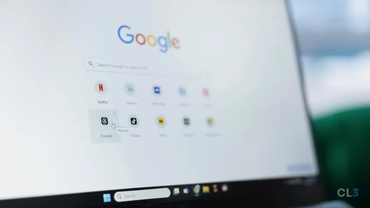 Tela de notebook fotografada de lado, com a página inicial do Google aberta: a barra de busca no meio e os atalhos de Netflix, Disney+, Threads e TikTok logo abaixo