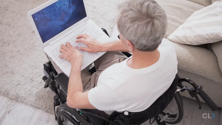 Homem em cadeira de rodas digitando em um notebook