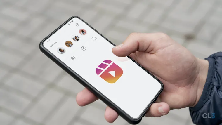 Mão segurando um celular com a tela do Instagram aberta e o ícone do Reels em destaque