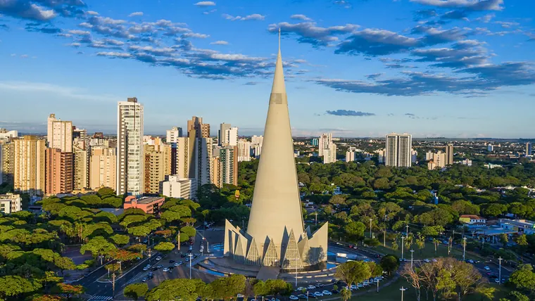 Vista aérea de Maringá com a catedral cônica ao centro, prédios à esquerda e arborização em volta