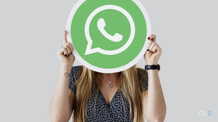 Mulher segurando o ícone do WhatsApp na frente do rosto