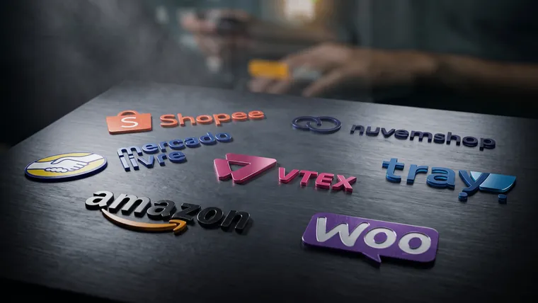 Logos em relevo de Shopee, Nuvemshop, Mercado Livre, VTEX, Tray, Amazon e WooCommerce sobre uma mesa escura, com uma pessoa pagando com cartão desfocada ao fundo